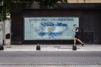 A person walks by a mural depicting the Falklands map with Argentine text in Buenos Aires.