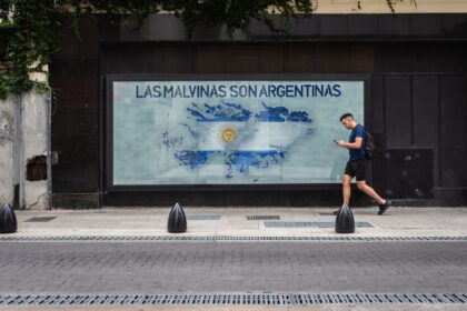 A person walks by a mural depicting the Falklands map with Argentine text in Buenos Aires.