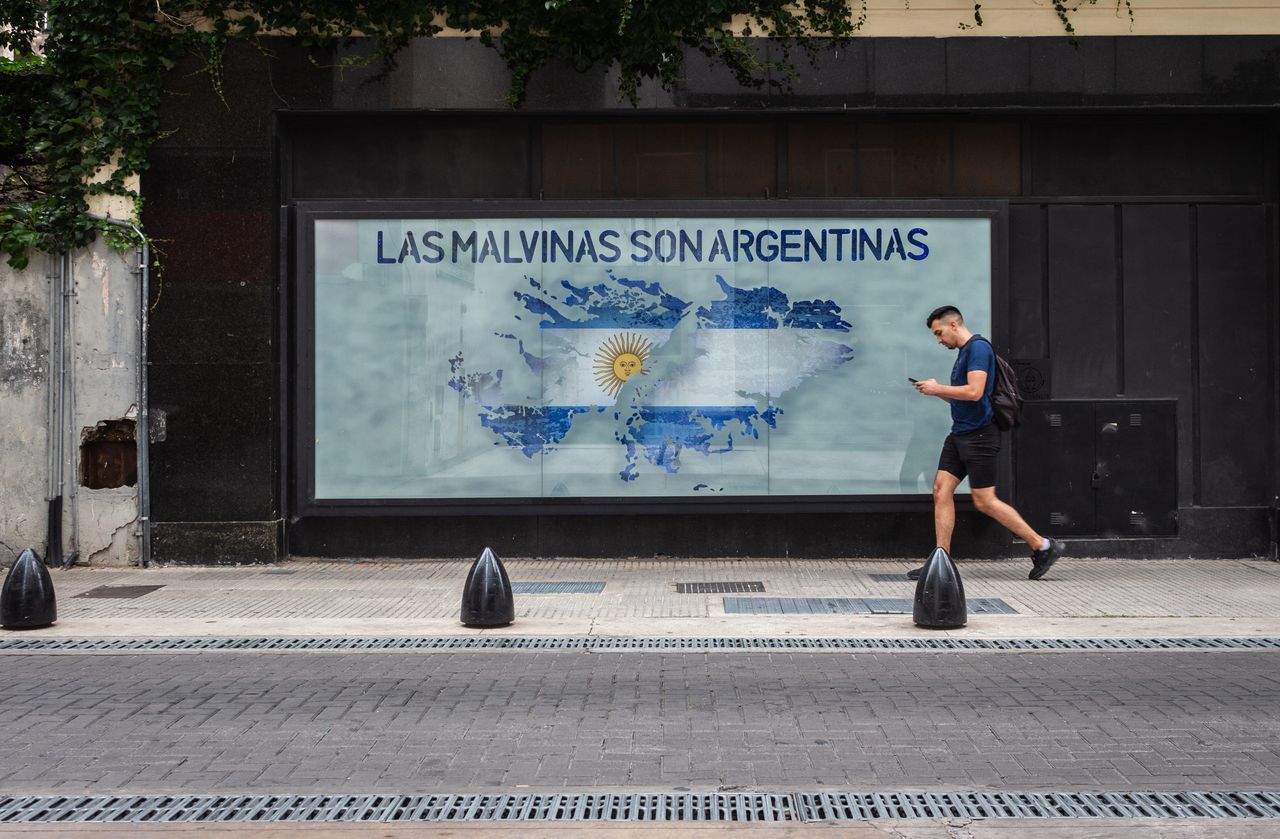A person walks by a mural depicting the Falklands map with Argentine text in Buenos Aires.